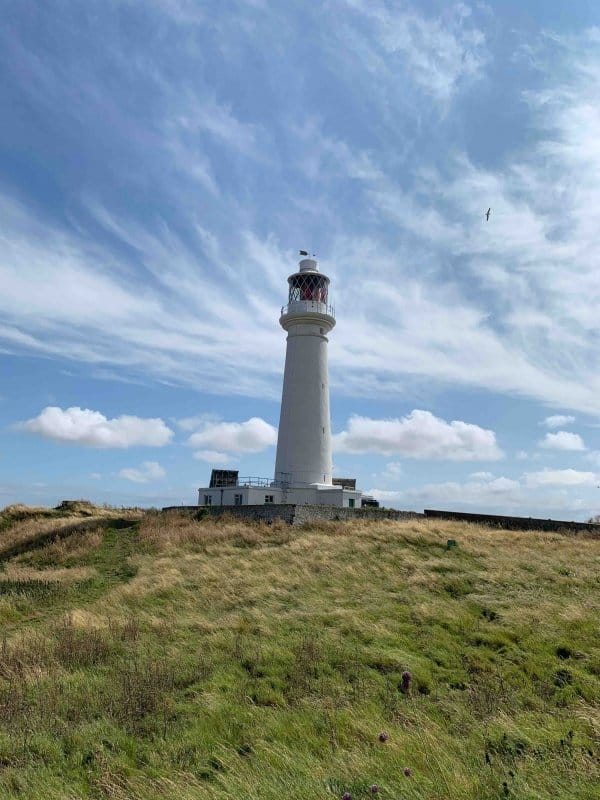 A picture of the lighthouse on Flat Holm Island, with fluffy clouds passing